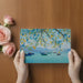 Calm coastal bedroom wall decor featuring blue water and boat scene above a wooden headboard