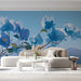 A bright, airy living room featuring the blue floral wallpaper behind a neutral fabric sofa.