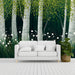 Large scale forest mural on an entryway wall behind a velvet sofa.