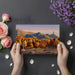 A cozy living room with a mountain landscape wallpaper mural on the main feature wall.