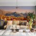 A bright, airy living room wall decorated with a peaceful, golden-hour mountain forest mural.
