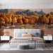 A spacious bedroom featuring a scenic autumn mountain road mural behind a walnut desk.