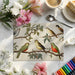 A soft, neutral nursery room with an elegant bird and branch mural providing a gentle nature-inspired focal point