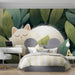 A tranquil bedroom nook decorated with a white cat and green leaves wallpaper