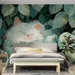A cozy bedroom with a peaceful cat and green foliage wallpaper behind the bed frame.