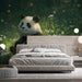 A cozy bedroom featuring a whimsical panda forest wallpaper behind a wooden crib.