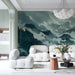 A serene living room featuring a misty mountain landscape wallpaper as a floor-to-ceiling focal point.