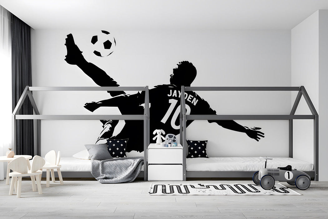 Sports-themed boy's bedroom with a large soccer player silhouette mural on the main wall
