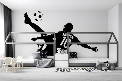 Sports-themed boy's bedroom with a large soccer player silhouette mural on the main wall