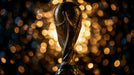 Golden championship trophy centered against a bokeh background of amber light