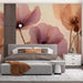 Floral bedroom wallpaper featuring elegant poppies behind a modern beige upholstered bed frame.