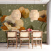 A cozy dining room with a sage and poppy floral mural behind a wooden headboard.