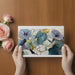 A light-filled home office with a floral blue watercolor wallpaper as a calming backdrop.