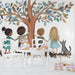 Kids room wall mural featuring a children and tree illustration above a cozy nursery