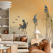 A cozy nursery featuring a birdhouse mural wall, soft textiles, and warm wooden furniture.