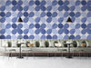 Modern cafe with periwinkle blue petal geometric wallpaper behind a wooden desk