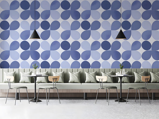 Modern cafe with periwinkle blue petal geometric wallpaper behind a wooden desk