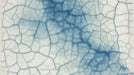 Close-up of a blue and white crackle glaze pattern with deep indigo fissures and ceramic textures