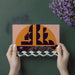 Bold graphic ship wallpaper featured in a stylish modern dining room with wooden accents.