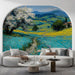 A cozy living room featuring the Tuscan meadow mural as a feature wall behind a beige linen sofa.