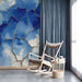 A modern study featuring the blue and white textured mural with minimalist wooden furniture and a hanging light.