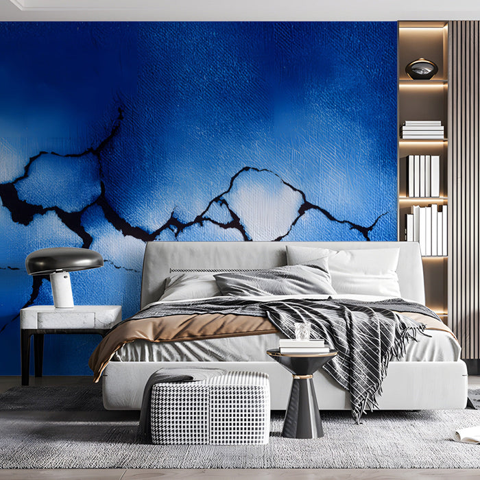 A modern bedroom featuring the blue crackle wall mural behind a dark gray velvet sofa.
