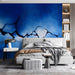A modern bedroom featuring the blue crackle wall mural behind a dark gray velvet sofa.