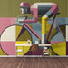 Geometric cyclist mural installed in a home office space behind a wooden desk.