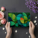 Creative home office wall with abstract foliage mural and wooden desk furniture