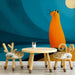 Whimsical cat wall mural installed in a modern nursery with mid-century wood furniture