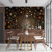 A moody dining room with a star-filled galaxy mural behind a headboard.