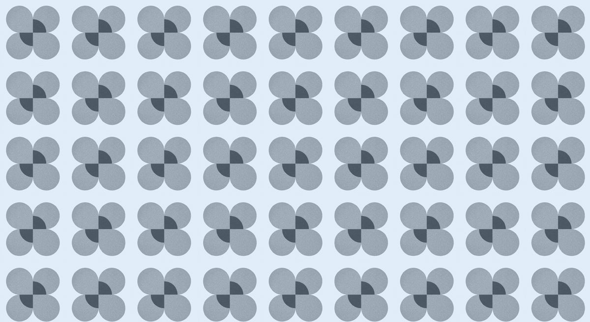 A repeating geometric pattern of blue flower motifs with charcoal centers on a light blue background.