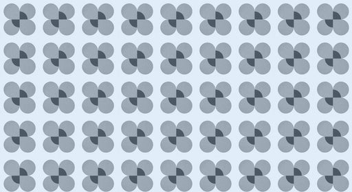 A repeating geometric pattern of blue flower motifs with charcoal centers on a light blue background.