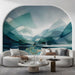 Abstract teal mountain wall mural installed in a modern minimalist living room with warm wood furniture.