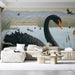 A cozy living room with a swan mural wall behind the headboard and light wood furniture.