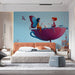 A cozy bedroom featuring a magical garden mural on the main wall behind a white wooden crib.