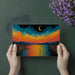 Living room with a vibrant coastal sunset mural behind a modern velvet sofa