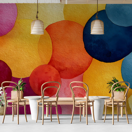 A modern cafe with a vibrant, artistic watercolor pattern on the wall behind a neutral sofa.