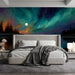Dramatic dark bedroom featuring a northern lights wall mural behind a king bed.