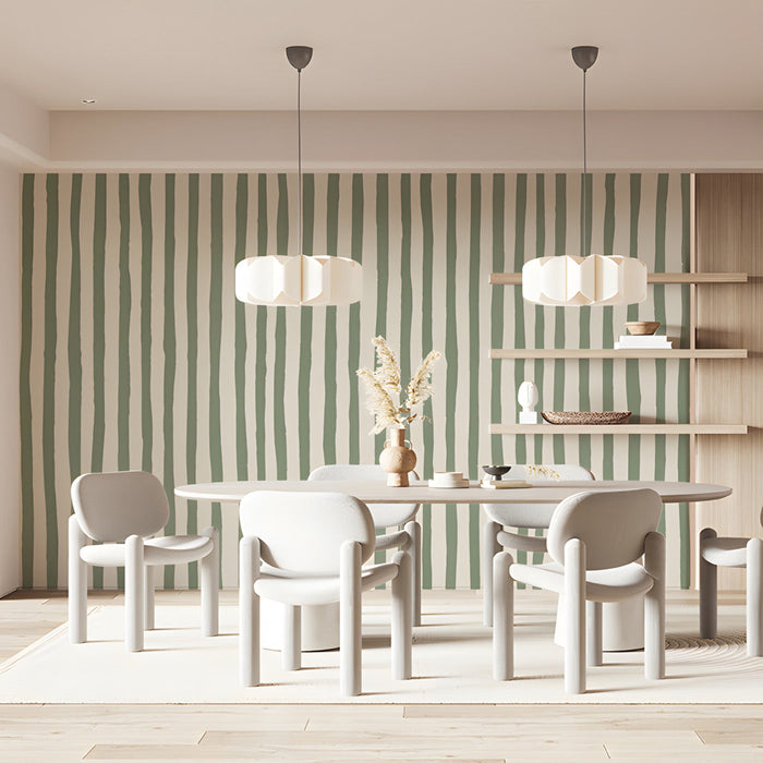A cozy home office with sage green striped wallpaper on a feature wall behind a wooden desk.