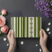 Minimalist home entryway decorated with sage and cream vertical stripe mural wallpaper