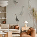 A living room wall featuring a light-hearted goose pattern in a cozy, neutral space.