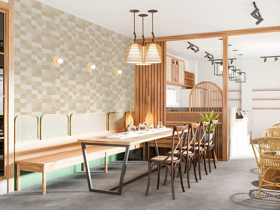 A bright, airy restaurant with a beige geometric grid wallpaper behind a neutral sofa.