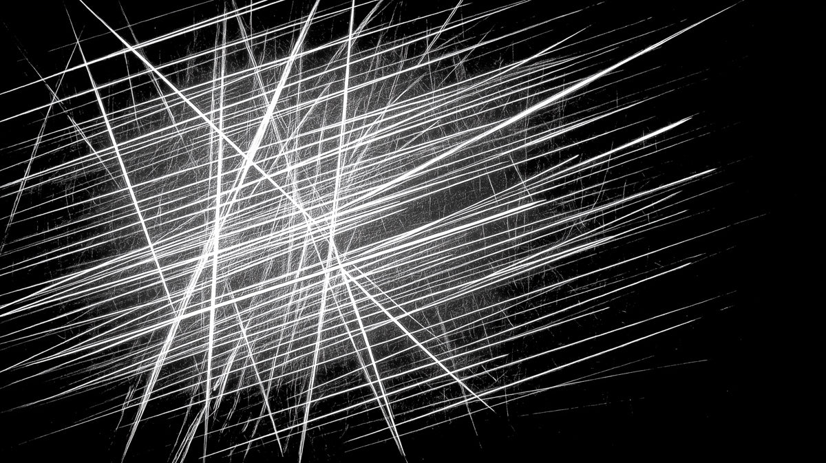 Abstract pattern of sharp white intersecting lines on a deep black background