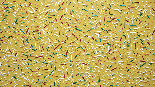 Ochre yellow mural wallpaper featuring scattered white, green, and red paint-like sprinkles