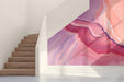 A modern living room featuring the abstract pink and purple marble mural behind a white sofa.