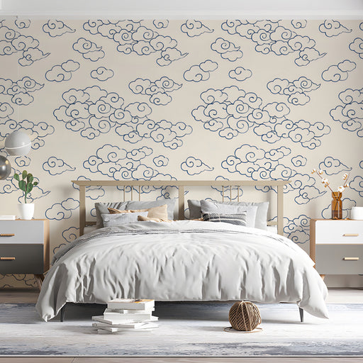 Bedroom featuring navy and cream cloud wallpaper behind a minimalist wooden sofa