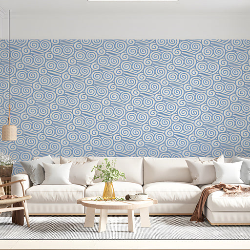Minimalist bedroom wall with blue cloud pattern behind a wooden bed frame