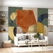 Modern living room wall featuring abstract geometric mural with warm earthy tones and gold details.