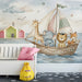 A tranquil playroom space with a soft blue sea and animal boat mural, styled with light wood furniture and cream textiles.